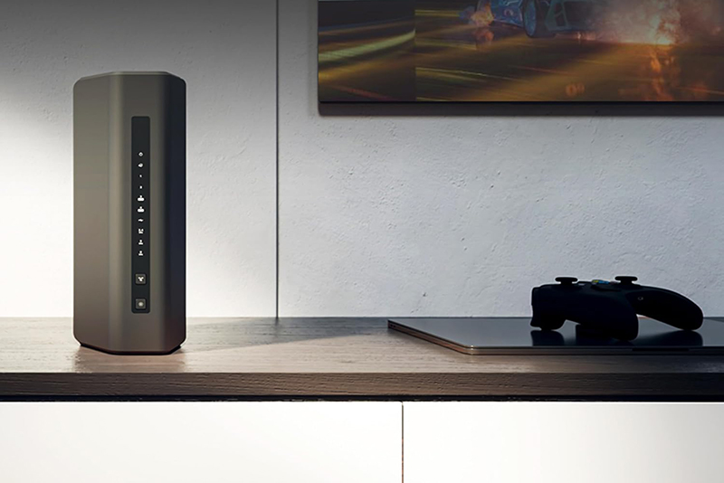 Le routeur Netgear Nighthawk RS300 au design vertical élégant est posé sur un meuble, illustrant son intégration discrète dans un intérieur moderne.