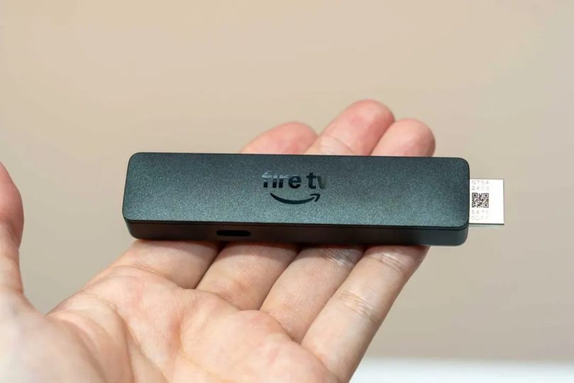 Amazon Fire TV Stick HD 2026 tenu dans une main, montrant son design affiné et son connecteur HDMI