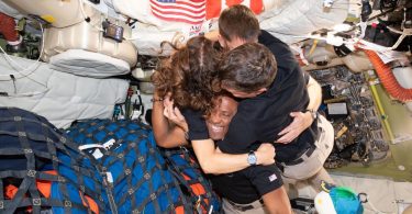 Quatre astronautes de la mission Artemis II, dont Victor Glover au centre, s'enlacent et célèbrent avec émotion à l'intérieur du module spatial Orion en apesanteur avant leur retour sur Terre.