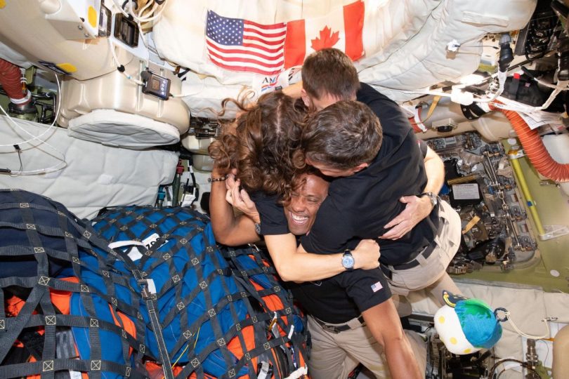 Quatre astronautes de la mission Artemis II, dont Victor Glover au centre, s'enlacent et célèbrent avec émotion à l'intérieur du module spatial Orion en apesanteur avant leur retour sur Terre.
