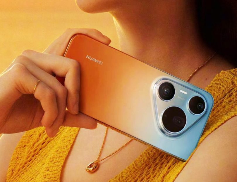 Gros plan sur le dos du Huawei Pura 90 Pro Max montrant son module photo triangulaire distinctif et son dégradé de couleurs allant de l'orange au bleu nacré.