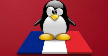 Mascotte Tux de Linux debout sur un socle aux couleurs du drapeau français, sur fond rouge uni. Symbole de la migration vers l'open source.