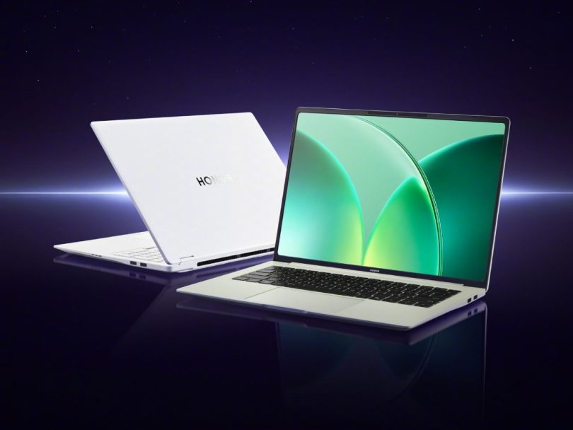 Deux ordinateurs portables Honor WIN de couleur blanche présentés sur une surface réfléchissante sombre : l'un fermé montrant le logo Honor argenté au dos, l'autre ouvert affichant un fond d'écran abstrait vert sur un écran à bordures fines, le tout sur fond galactique violet.