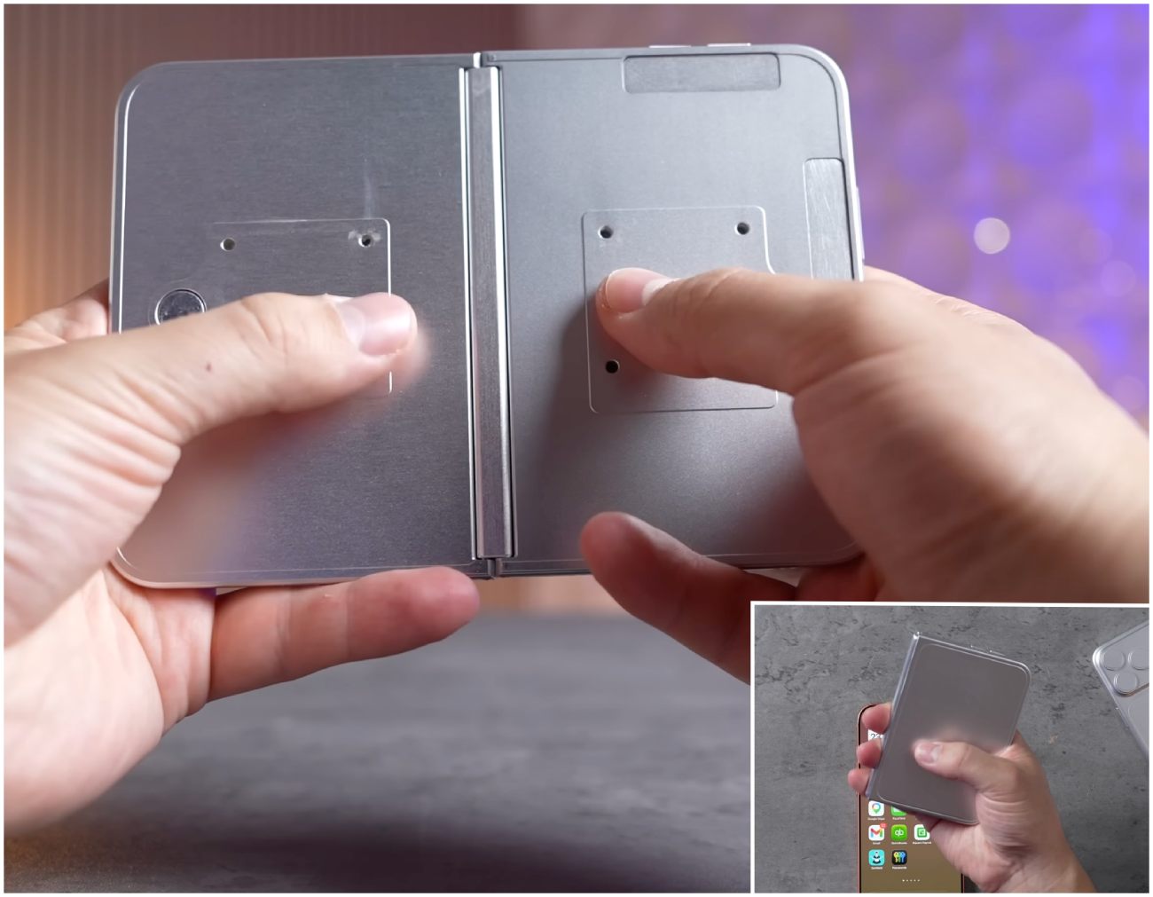 Gros plan sur les mains d'un utilisateur manipulant le châssis en aluminium brossé d'un prototype d'iPhone pliable, montrant les détails de la charnière centrale et l'emplacement des futurs boutons avec Touch ID intégré.