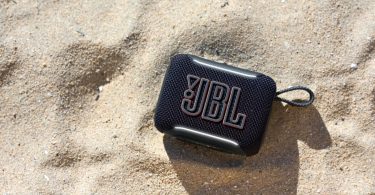 JBL Go 5 posée sur le sable de plage, mini enceinte Bluetooth portable étanche IP68