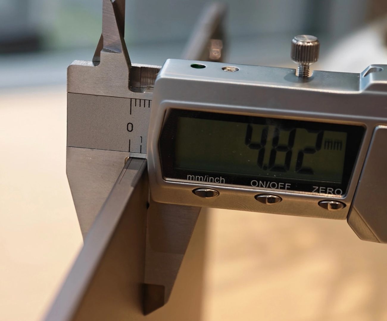 Gros plan sur un pied à coulisse numérique mesurant l'épaisseur ultra-fine de la tablette Honor OLED à 4.82 mm. L'écran affiche clairement la valeur.