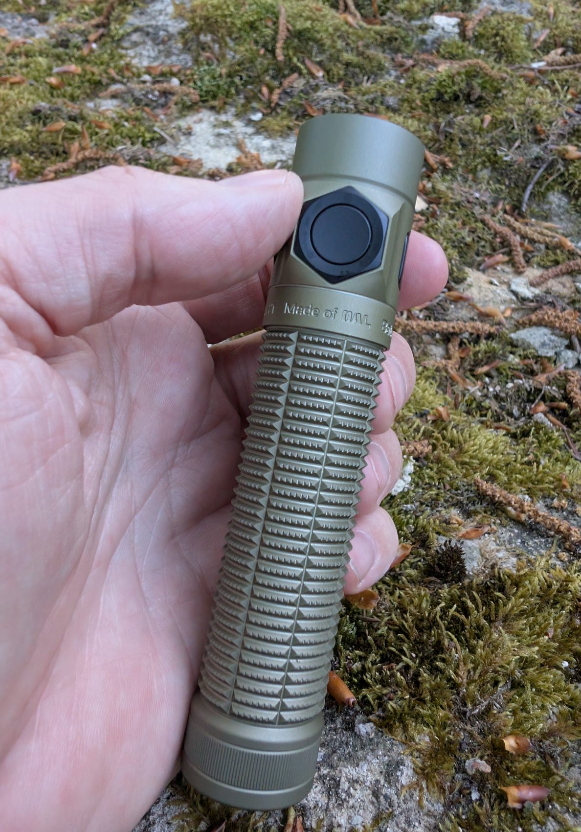 Prise en main Olight Baton Ultra Desert Tan - grip naturel, pouce sur le side button hexagonal