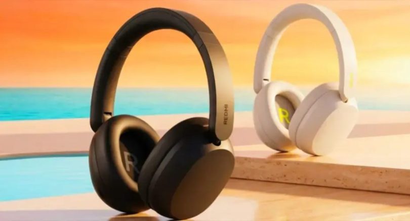 Casques Redmi Headphones Neo présentés en deux coloris côte à côte sur un décor de plage au coucher du soleil : modèle Obsidian Black à gauche avec arceau argent métallique et logo R discret, modèle Sand White à droite avec accent jaune lime sur le logo R sur la coque