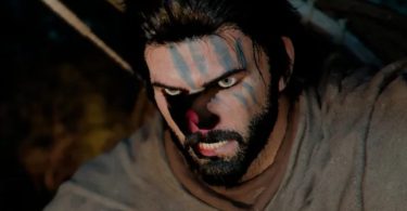 Capture d'écran du jeu Crimson Desert : plan rapproché sur le visage d'un personnage (Kliff) montrant des bugs de texture prononcés (pixels noirs et décolorations) sur le nez et les yeux, illustrant les problèmes de rendu sur les GPU Intel Arc avant les correctifs. Les sous-titres en bas affichent "Kliff Giles... Rest well."