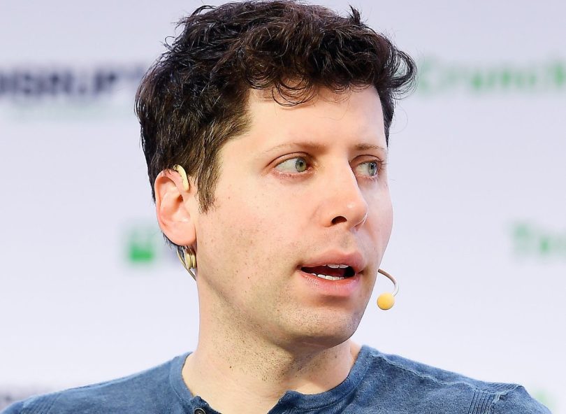Portrait serré de Sam Altman, PDG d'OpenAI, s'exprimant avec un micro-casque lors d'une conférence technique.