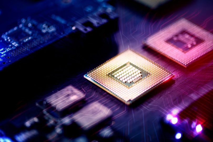 Gros plan sur des micro-processeurs et puces mémoire RAM sur un circuit imprimé avec des effets de lumière rouge et bleue, illustrant la production de composants Samsung.