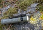 Test Olight Baton Ultra Desert Tan 2026 - lampe allumée en conditions réelles, faisceau EIP 1 sur rocher moussu