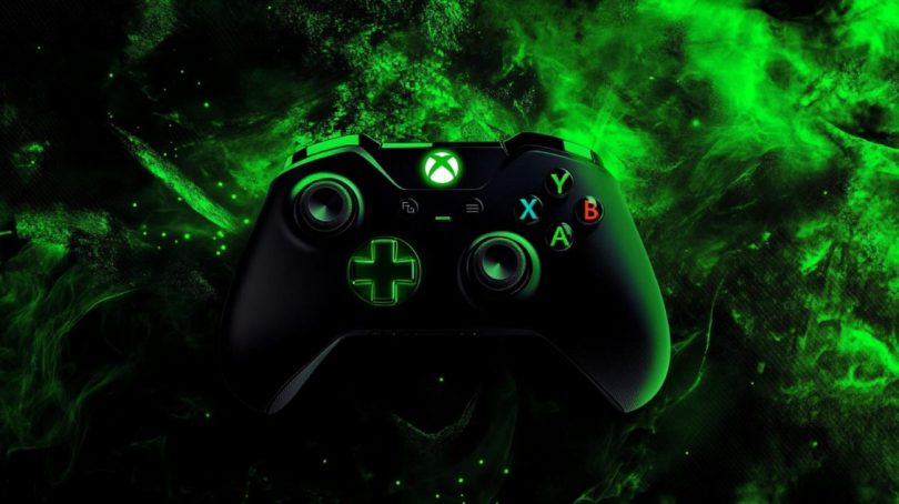 Manette Xbox noire avec logo et croix directionnelle rétroéclairés en vert néon, sur un fond de fumée émeraude stylisée évoquant l'identité visuelle historique de la marque.