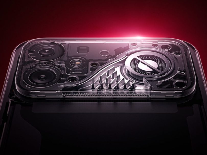Vue en éclatée de la partie supérieure arrière du Xiaomi Redmi K90 Max révélant un ventilateur de refroidissement interne de 18,1 mm, un dissipateur thermique à ailettes et un triple module caméra sous une coque transparente, sur fond rouge dégradé.