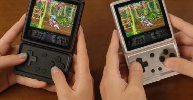 Deux consoles portables Anbernic RG Rotate, l'une en plastique ABS noir et l'autre en aluminium argenté, affichant un jeu de combat rétro sur leur écran LCD carré de 3,5 pouces. On distingue le D-pad et les boutons d'action sous l'écran pivotant.