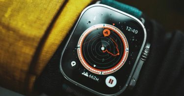 Gros plan sur le cadran de l'Apple Watch Ultra 4 en conditions réelles affichant une interface de navigation plein air. Des gouttes d'eau sur l'écran et le boîtier robuste illustrent sa résistance, s'appuyant sur ses nouveaux capteurs de santé et de sport.