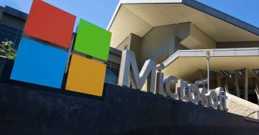 Logo coloré et enseigne métallique de Microsoft devant les locaux de l'entreprise. Microsoft a débuté le déploiement de ses nouveaux certificats Secure Boot pour remplacer ceux de 2011.