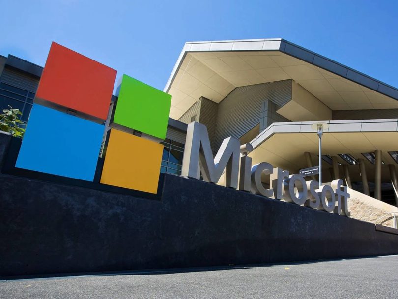Logo coloré et enseigne métallique de Microsoft devant les locaux de l'entreprise. Microsoft a débuté le déploiement de ses nouveaux certificats Secure Boot pour remplacer ceux de 2011.