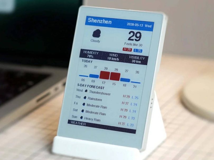 Boîtier M5Paper Color ESP32S3 affichant une interface météo colorée à Shenzhen sur son écran e-ink de 4 pouces, posé sur un support blanc à côté d'un ordinateur portable.