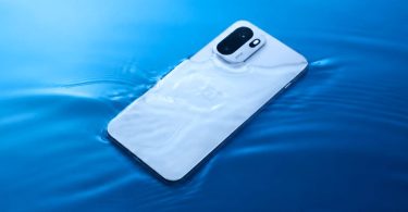 Le smartphone OnePlus Ace 7 blanc flotte à la surface d'une eau bleu vif, avec des ondulations. Le double module caméra vertical avec le marquage "Ace" et le logo OnePlus sont visibles.