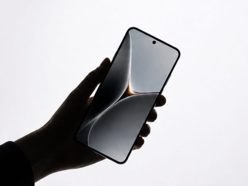Main tenant un smartphone au design minimaliste affichant une interface abstraite fluide, illustrant le futur appareil mobile d'OpenAI doté d'une puce NPU de 50 TOPS.