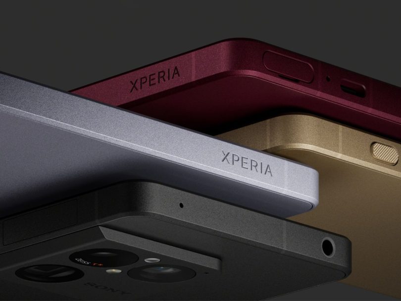 Gros plan sur les tranches élégantes du Sony Xperia 1 VIII montrant quatre coloris différents : noir mat, gris sidéral, bordeaux profond et or brossé. On distingue le logo Xperia gravé, le bouton d'alimentation et le module photo optique ZEISS T*.
