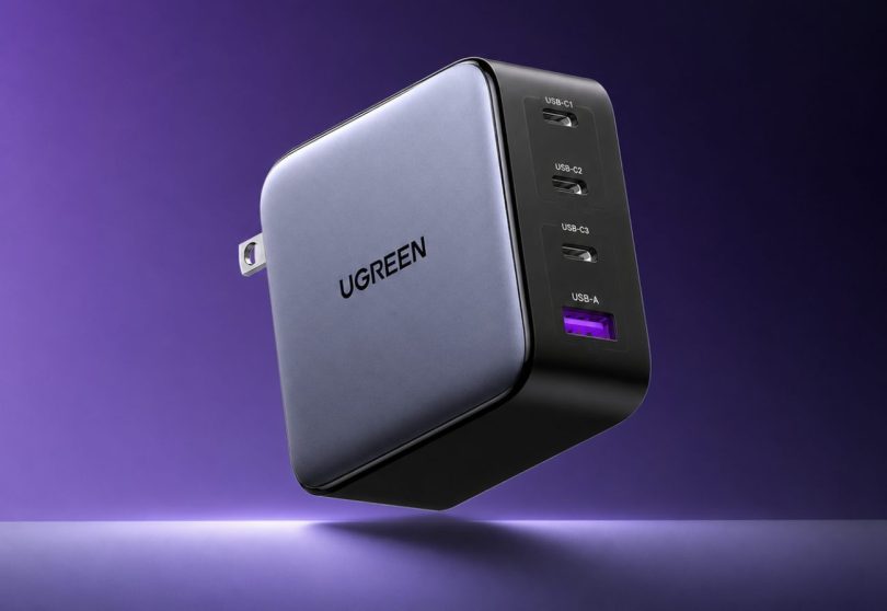 Chargeur secteur UGREEN Nexode 100W (référence CD226) en finition gris foncé satiné avec face avant en plastique noir laqué présentant les quatre ports de connexion étiquetés USB-C1 USB-C2 USB-C3 et USB-A en haut, fiche secteur avec broches pliables visibles à gauche, logo UGREEN gravé en lettres noires sur la face latérale, mise en scène lifestyle premium sur fond violet dégradé avec halo lumineux blanc en arrière-plan évoquant la technologie GaN et la performance de charge rapide
