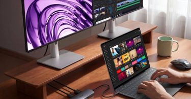 Hub USB-C 8-en-1 Nano d'Anker branché à un ordinateur portable sur un bureau en bois, gérant un double affichage fluide sur deux moniteurs externes en 4K.