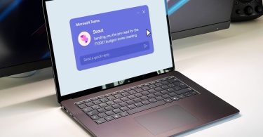 Un ordinateur portable affichant une notification de l'agent IA Microsoft Scout dans Microsoft Teams, illustrant son intégration omniprésente dans les tâches professionnelles quotidiennes.