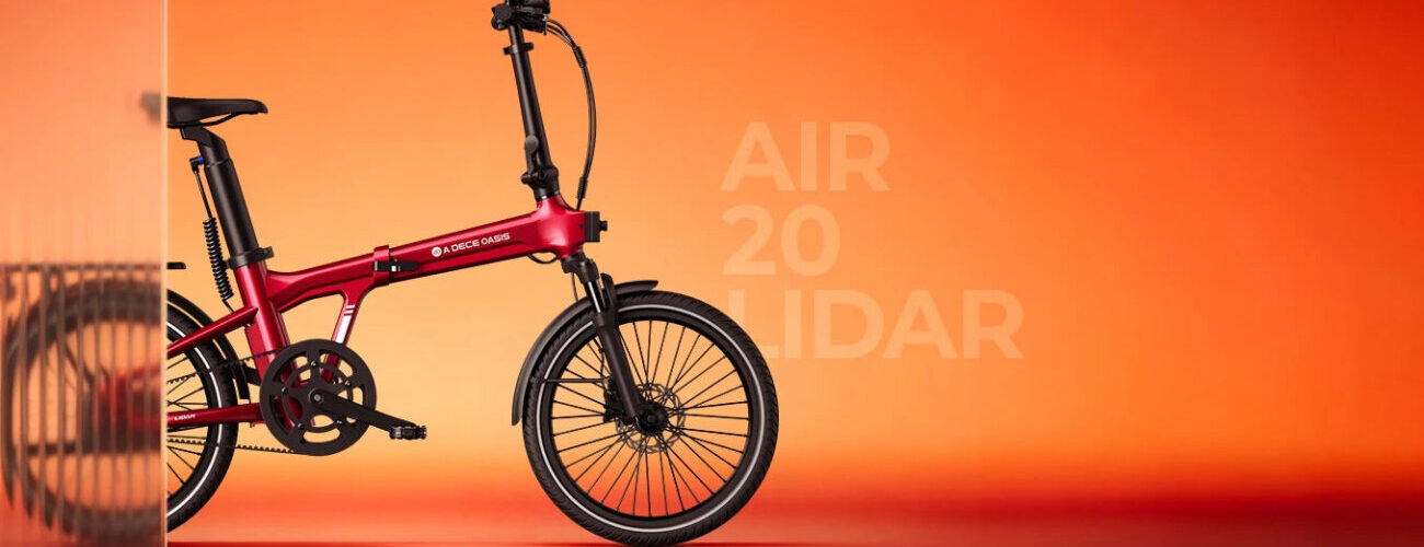 Vélo électrique pliant ADO Air 20 LiDAR rouge vu de profil sur fond orangé, roues de 20 pouces, fourche suspendue, freins à disque et transmission par courroie