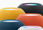 Cinq enceintes HomePod mini actuelles regroupées, en jaune, minuit, orange, bleu et blanc, avec leur dessus tactile lumineux