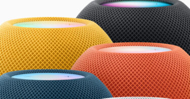 Cinq enceintes HomePod mini actuelles regroupées, en jaune, minuit, orange, bleu et blanc, avec leur dessus tactile lumineux