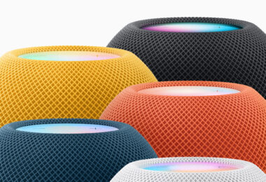 Cinq enceintes HomePod mini actuelles regroupées, en jaune, minuit, orange, bleu et blanc, avec leur dessus tactile lumineux