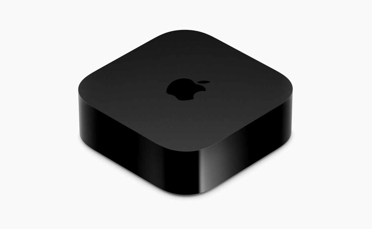 Boîtier Apple TV 4K actuel, noir et carré aux angles arrondis avec le logo Apple sur le dessus, photographié en vue plongeante sur fond blanc avant l'événement Welcome Home