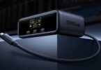 Station d'accueil Baseus Spacemate RD1 Mini 10 en 1 avec écran d'état affichant la puissance de charge, ports USB-C en façade et câble USB-C tressé intégré, sur un bureau à deux moniteurs