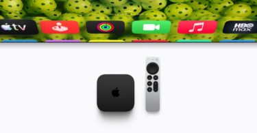 Boîtier noir Apple TV 4K de quatrième génération posé à côté de sa télécommande Siri Remote argentée, sous un téléviseur affichant les icônes des applications