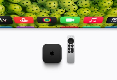 Boîtier noir Apple TV 4K de quatrième génération posé à côté de sa télécommande Siri Remote argentée, sous un téléviseur affichant les icônes des applications