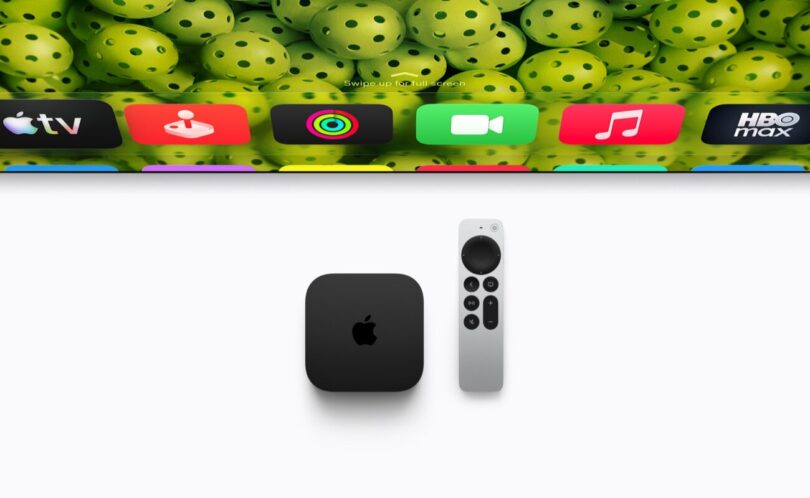 Boîtier noir Apple TV 4K de quatrième génération posé à côté de sa télécommande Siri Remote argentée, sous un téléviseur affichant les icônes des applications