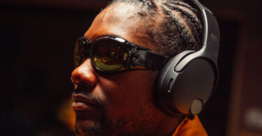 Homme portant le casque circum-auriculaire Skullcandy Crusher 1080 ANC noir, équipé de la réduction de bruit et de l'audio spatial Bose, illustration du rachat de Skullcandy par Bose