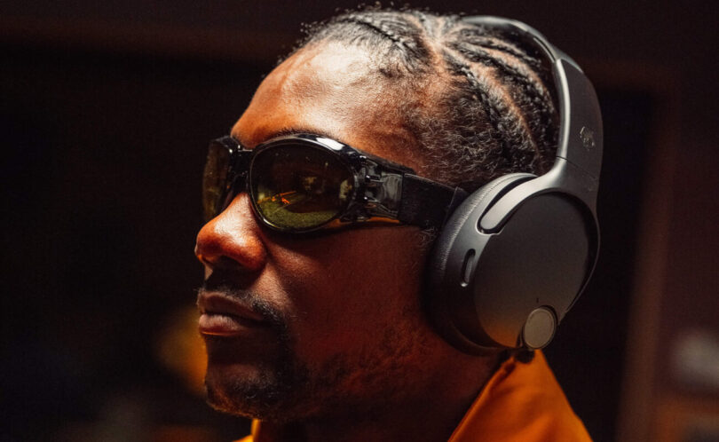 Homme portant le casque circum-auriculaire Skullcandy Crusher 1080 ANC noir, équipé de la réduction de bruit et de l'audio spatial Bose, illustration du rachat de Skullcandy par Bose