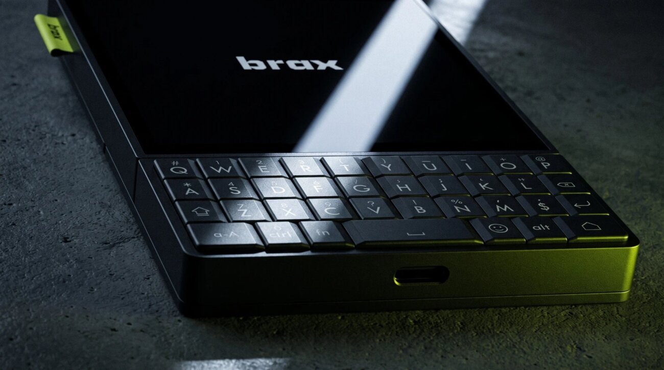Gros plan sur le clavier QWERTY physique du Brax Wink, sous l'écran noir frappé du logo brax, avec le port USB-C sur la tranche inférieure