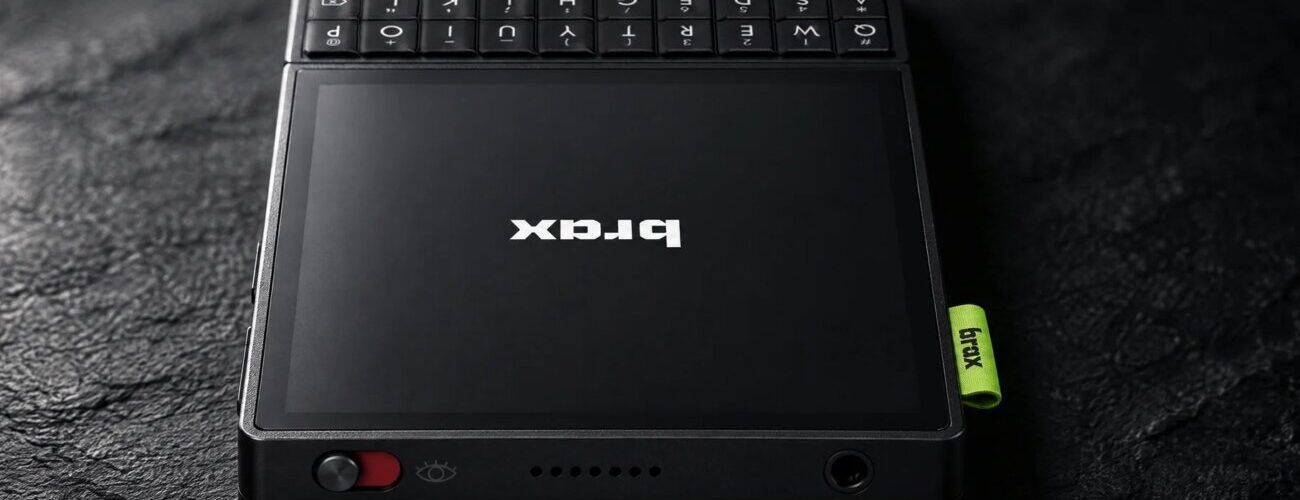 Smartphone Brax Wink noir posé sur une surface sombre, avec son écran OLED de 4 pouces, son clavier QWERTY physique au-dessus et l'interrupteur de confidentialité rouge sur la tranche
