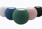 Cinq HomePod mini 2 en blanc, bleu, vert, rose et minuit, le dessus illuminé par la fonction Illumination sonore