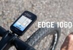 Le compteur vélo GPS Garmin Edge 1060 fixé sur le cintre d'un vélo de route, écran tactile 3,5 pouces affichant une alerte nid-de-poule