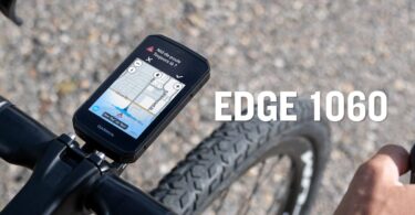 Le compteur vélo GPS Garmin Edge 1060 fixé sur le cintre d'un vélo de route, écran tactile 3,5 pouces affichant une alerte nid-de-poule