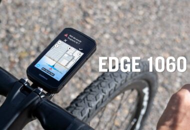 Le compteur vélo GPS Garmin Edge 1060 fixé sur le cintre d'un vélo de route, écran tactile 3,5 pouces affichant une alerte nid-de-poule