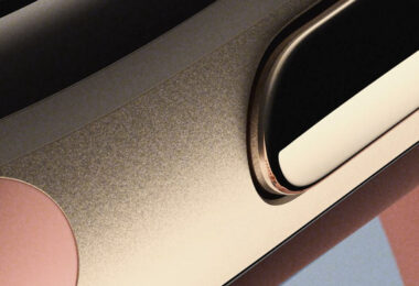 Teaser officiel du Google Fitbit Edge montrant en gros plan la tranche du boîtier métallique coloris Canyon, son bouton latéral et le bord de l'écran du bracelet connecté