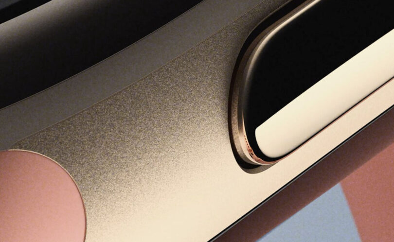 Teaser officiel du Google Fitbit Edge montrant en gros plan la tranche du boîtier métallique coloris Canyon, son bouton latéral et le bord de l'écran du bracelet connecté