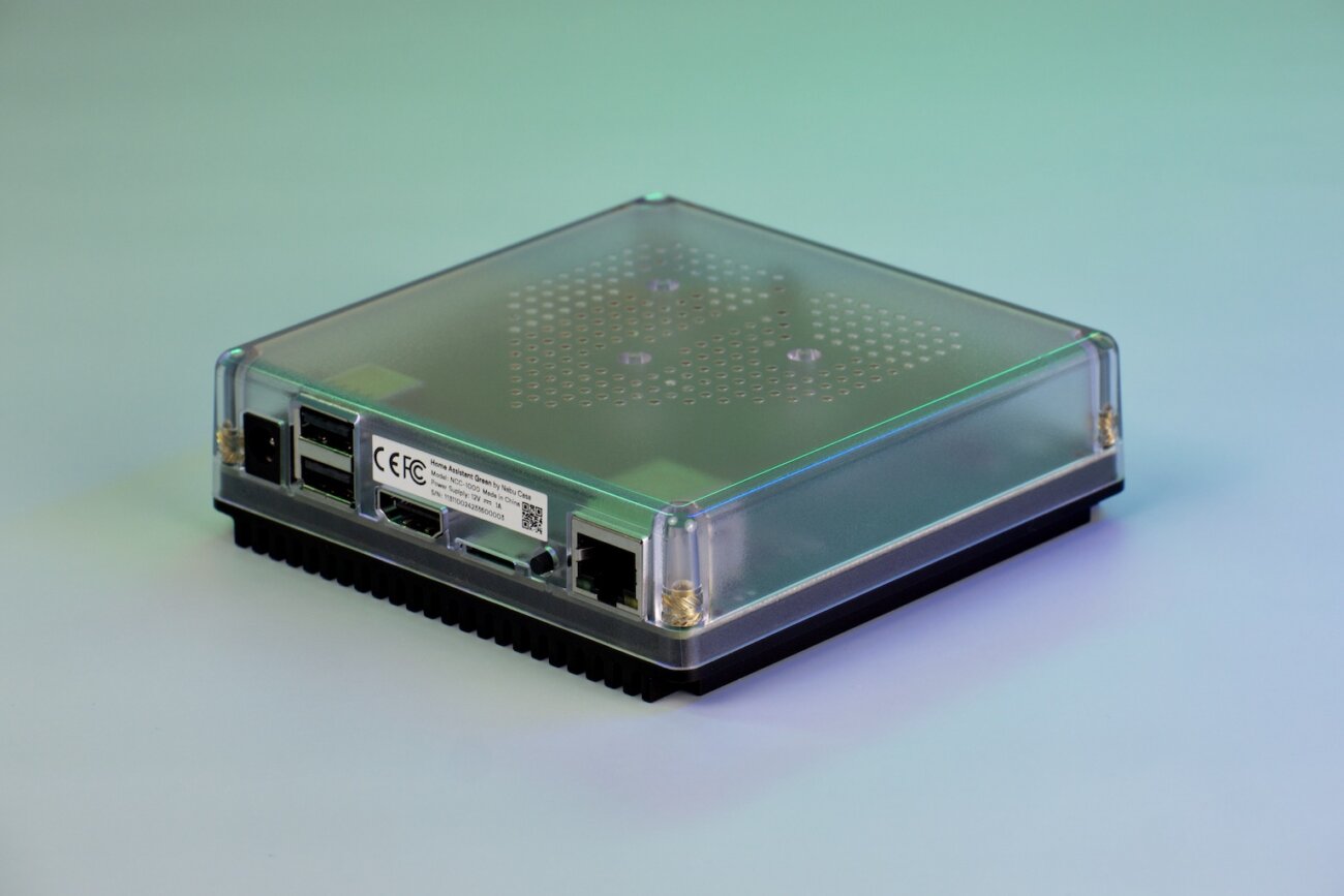 Face arrière de la box Home Assistant Green montrant l'entrée d'alimentation, deux ports USB, une sortie HDMI et un port Ethernet sous le boîtier transparent