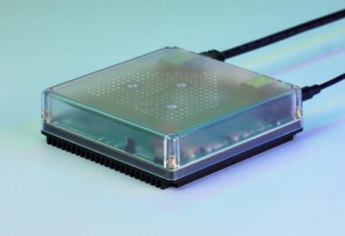 Box domotique Home Assistant Green avec son boîtier transparent et son dissipateur noir, branchée sur fond bleu vert, alternative prête à l'emploi au mini PC installé par clé USB